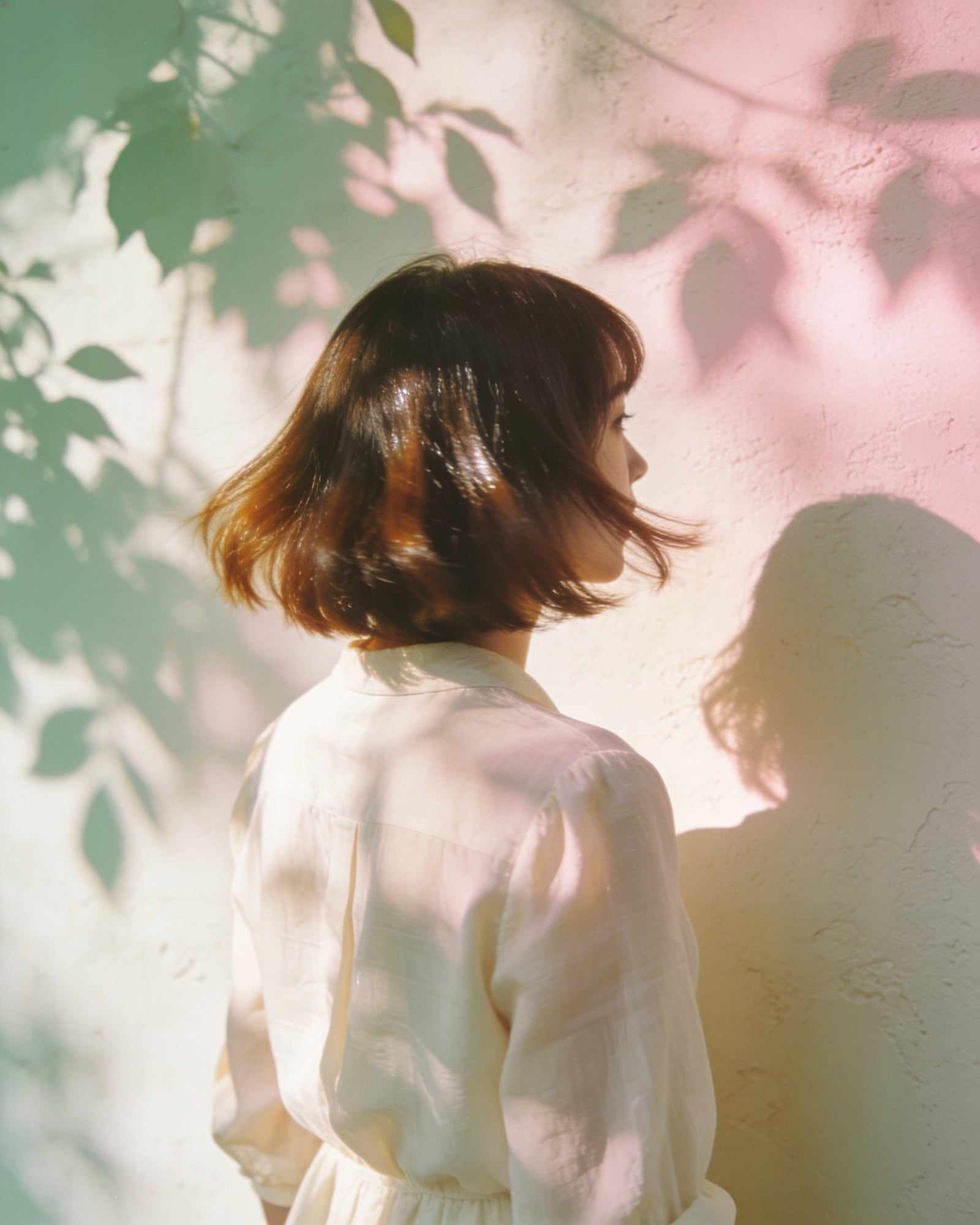 A woman with a glossy chin-length bob that bends softly at the ends, seen from behind.